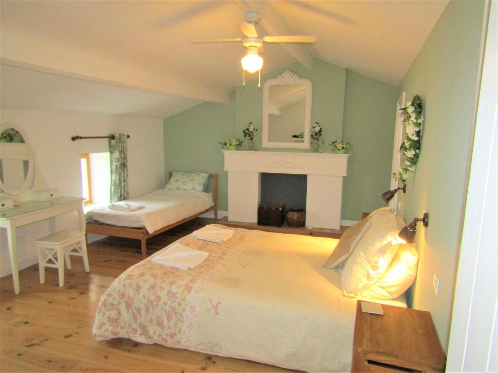 - une chambre avec un grand lit et une cheminée dans l'établissement Noyer, à Étusson