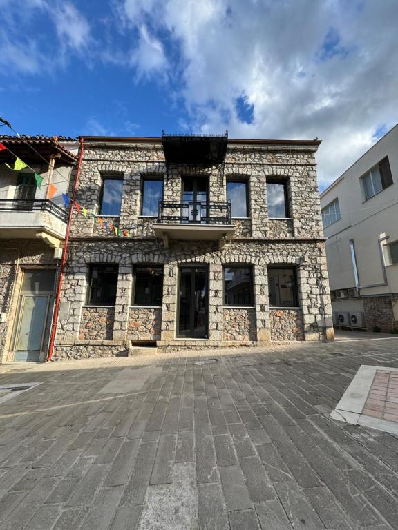 a stone building with a balcony on top of it at Amfikleia Earth houses in Amfikleia