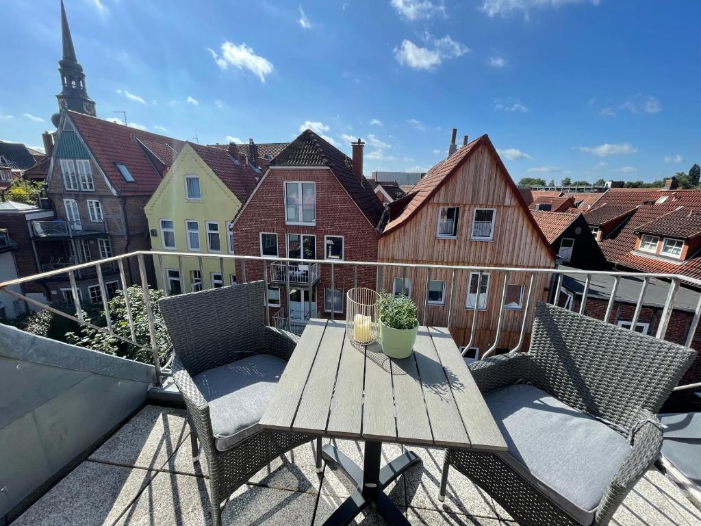 a balcony with a wooden table and chairs on a balcony at Altstadtlage 4 in Stade