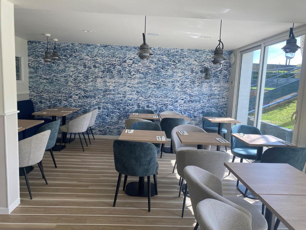 a restaurant with tables and chairs and a blue wall at Quality Hotel La Marebaudière Vannes Centre in Vannes
