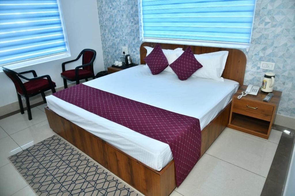 Hotel Shiwalik Enclave في Baddi: غرفة نوم بسرير كبير ومخدات حمراء