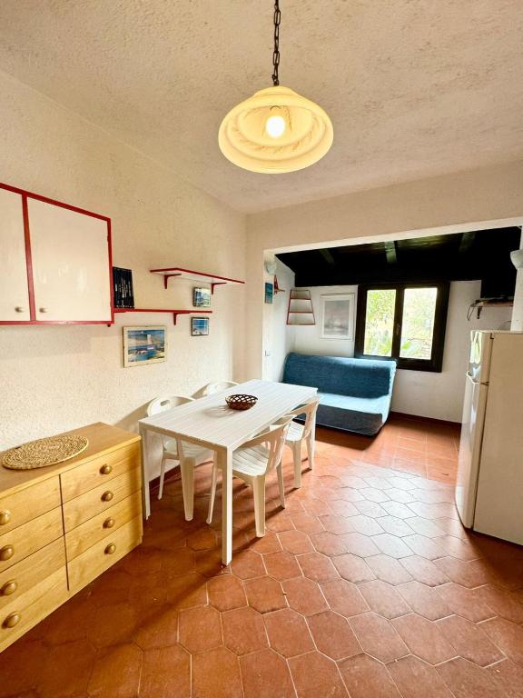a kitchen with a white table and a blue couch at Bilocale al Villaggio degli ulivi SAN TEODORO in San Teodoro