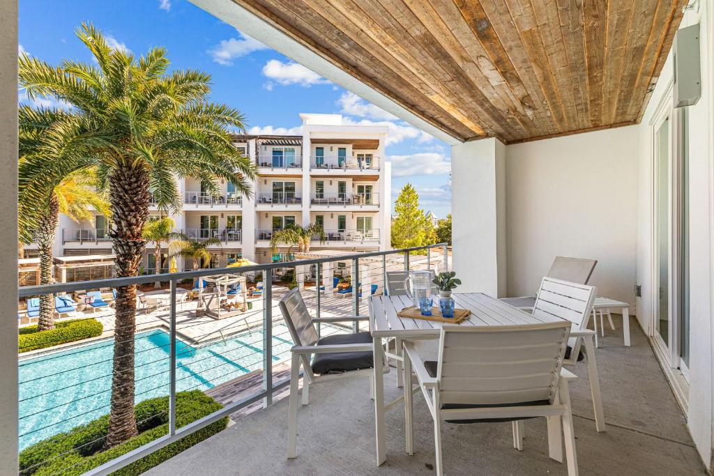 a balcony with a table and chairs and a pool at the Pointe Unit 125 in Rosemary Beach
