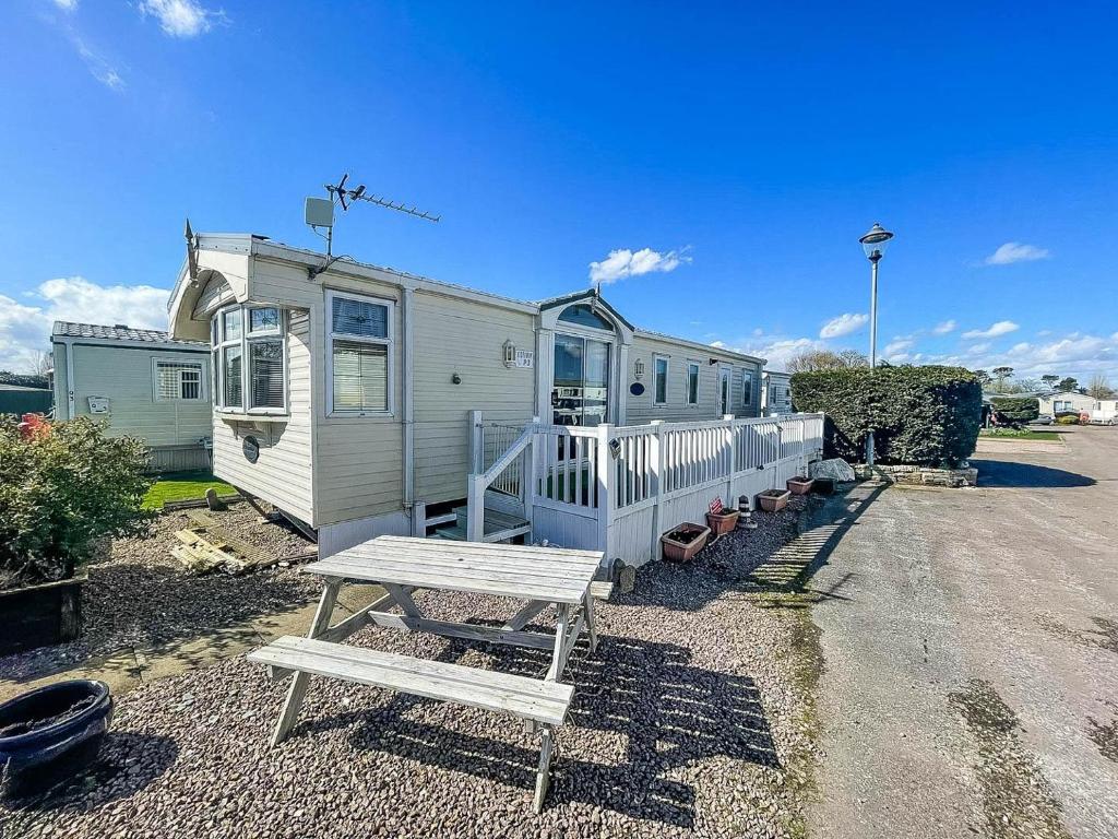 a white trailer with a bench and a house at 8 Berth Caravan With Wifi And Decking In Lincs Ref 78003p in Winthorpe