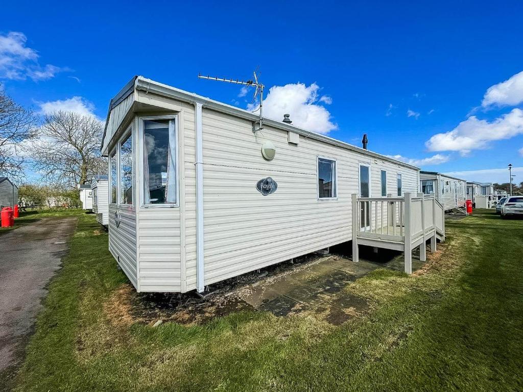 un mobile home blanc avec une terrasse couverte sur la pelouse dans l'établissement Superb 6 Berth Caravan At Sunnydale Holiday Park Ref 35079a, à Louth