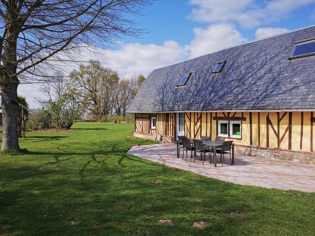 une maison avec une table et des chaises devant elle dans l'établissement La Bergerie, à Cambremer