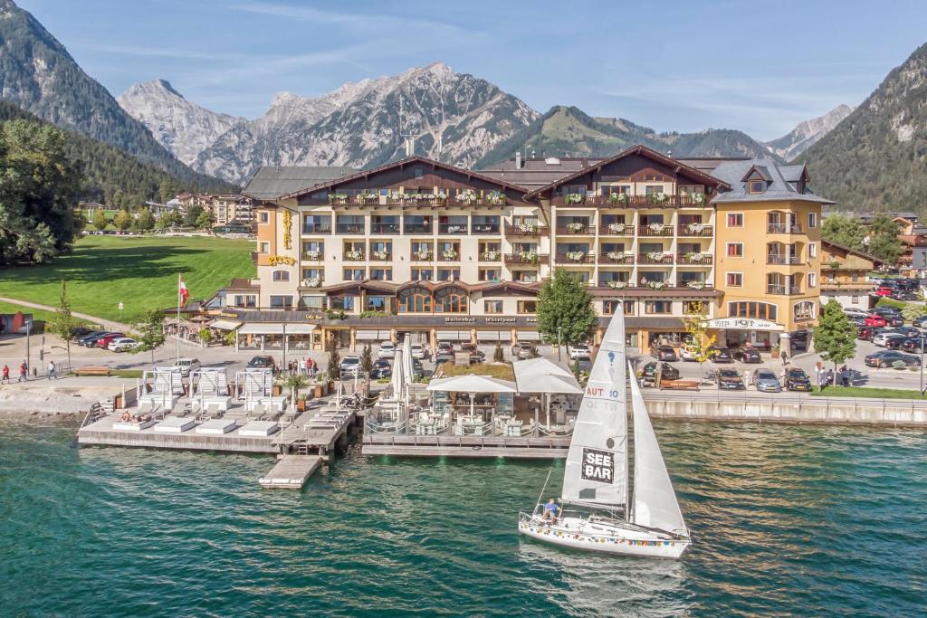 a sailboat in the water in front of a hotel at Hotel Post am See in Pertisau