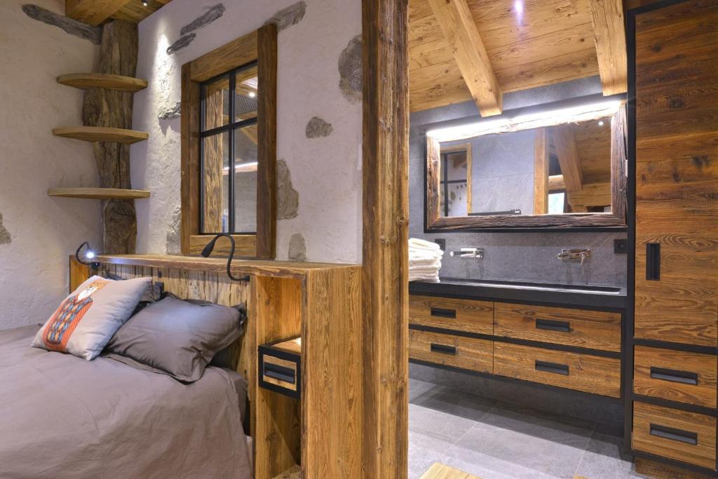 a bedroom with a bed and a large mirror at La cabane luxury apartment in the heart of the village in La Grave