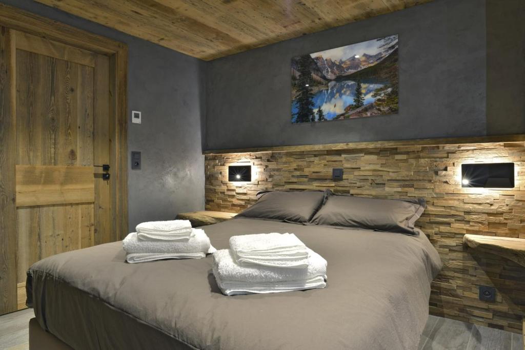 a bedroom with a bed with towels on it at La cabane luxury apartment in the heart of the village in La Grave