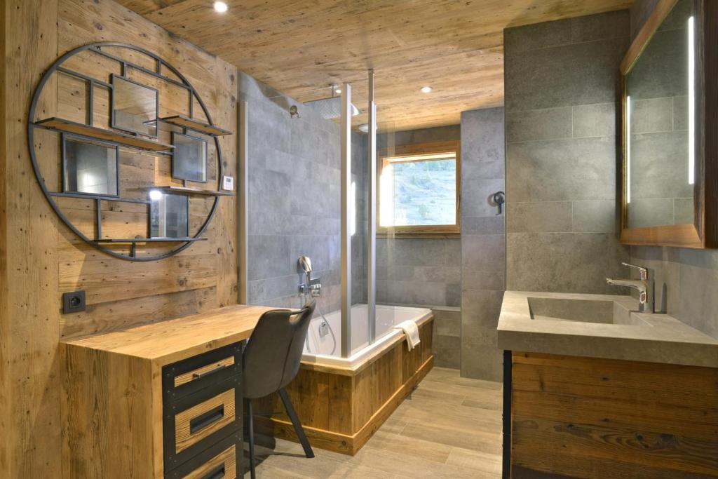 a bathroom with a sink and a tub and a desk at La cabane luxury apartment in the heart of the village in La Grave