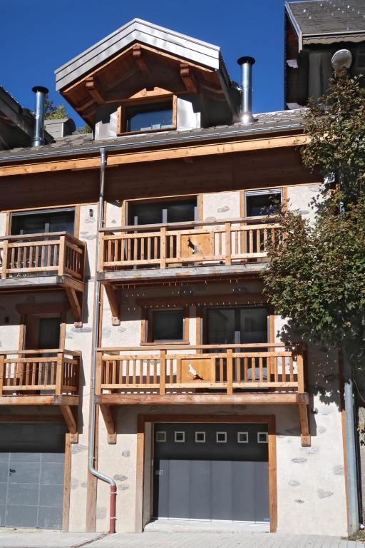 a building with wooden balconies on the side of it at La cabane luxury apartment in the heart of the village in La Grave