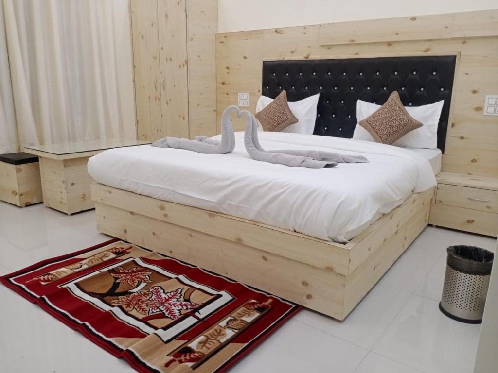 a bedroom with a large bed with swans on it at Uk09 hotel & Restaurant in Mussoorie