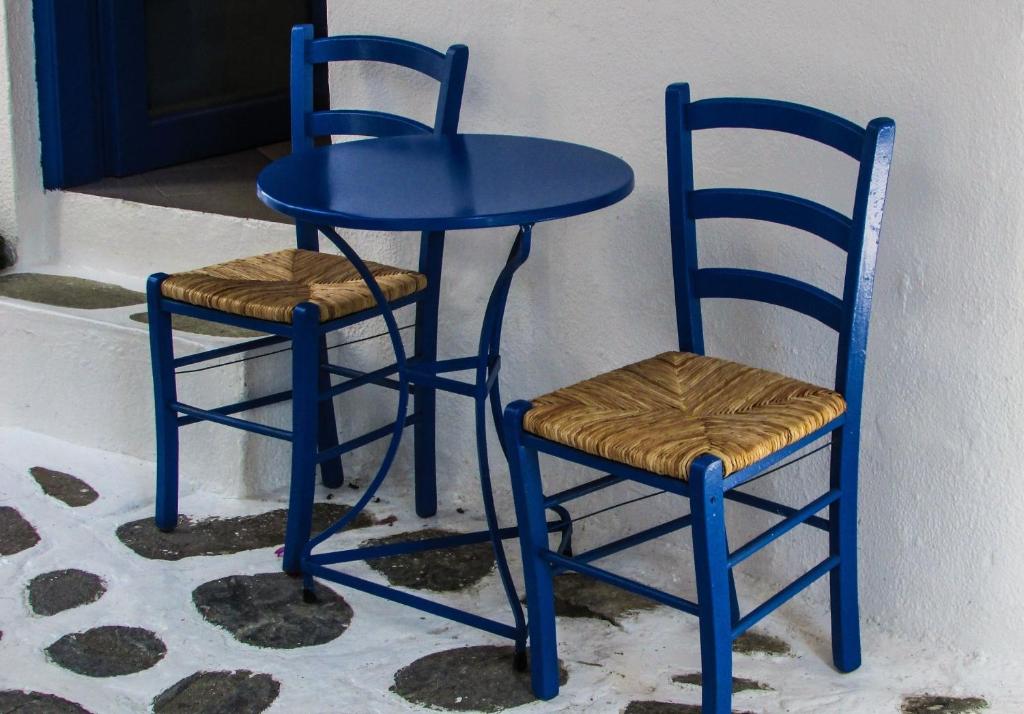 a blue table and two chairs next to a door at Magnificent Athens Villa 1 Bedroom Villa Aizen Garden View Ground Floor Platia Agion Asomaton in Athens
