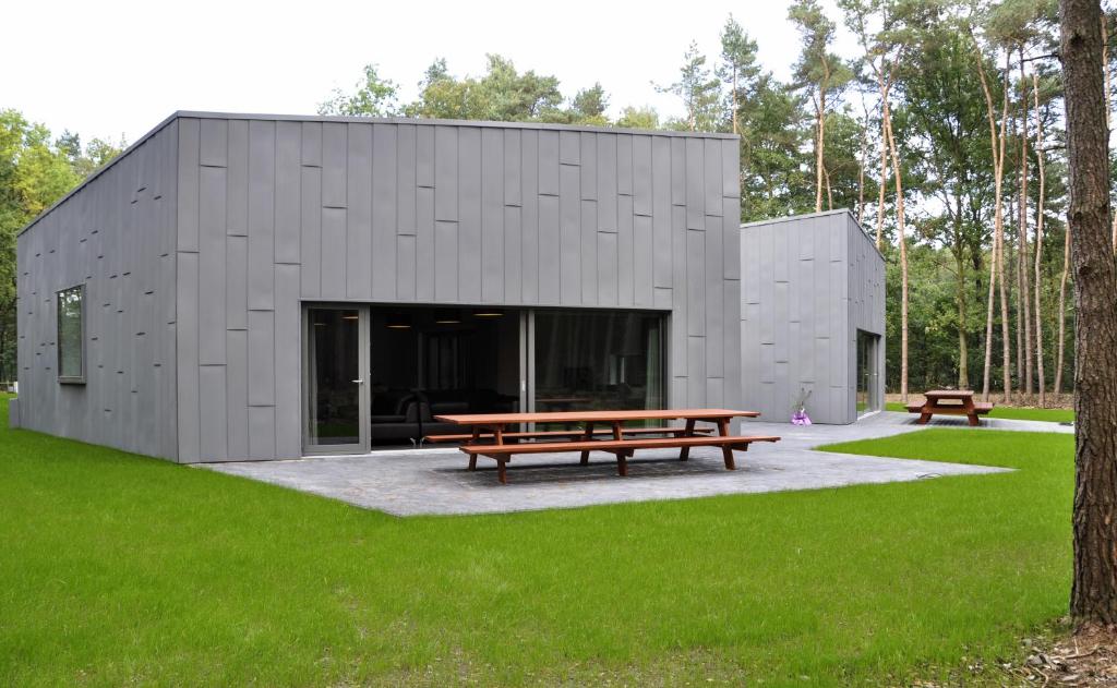 een gebouw met een picknicktafel in een park bij Twinstone Lodge in Genk