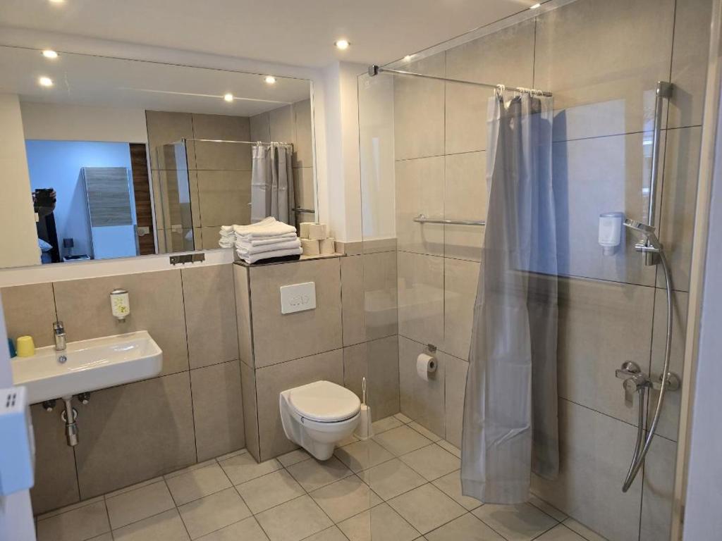 ein Bad mit einer Dusche, einem WC und einem Waschbecken in der Unterkunft Balthasar Neumann Speiserei & Gästehaus - Zentrum Brühl - in Brühl