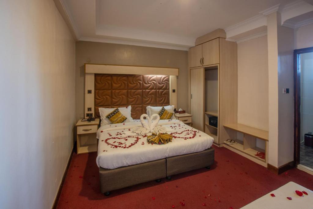Postel nebo postele na pokoji v ubytování The Luke Hotel Cravers Thika