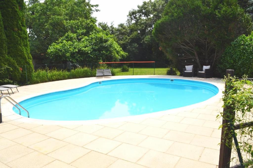 a large blue pool with two chairs around it at Les Bruyeres B&B in Montbron