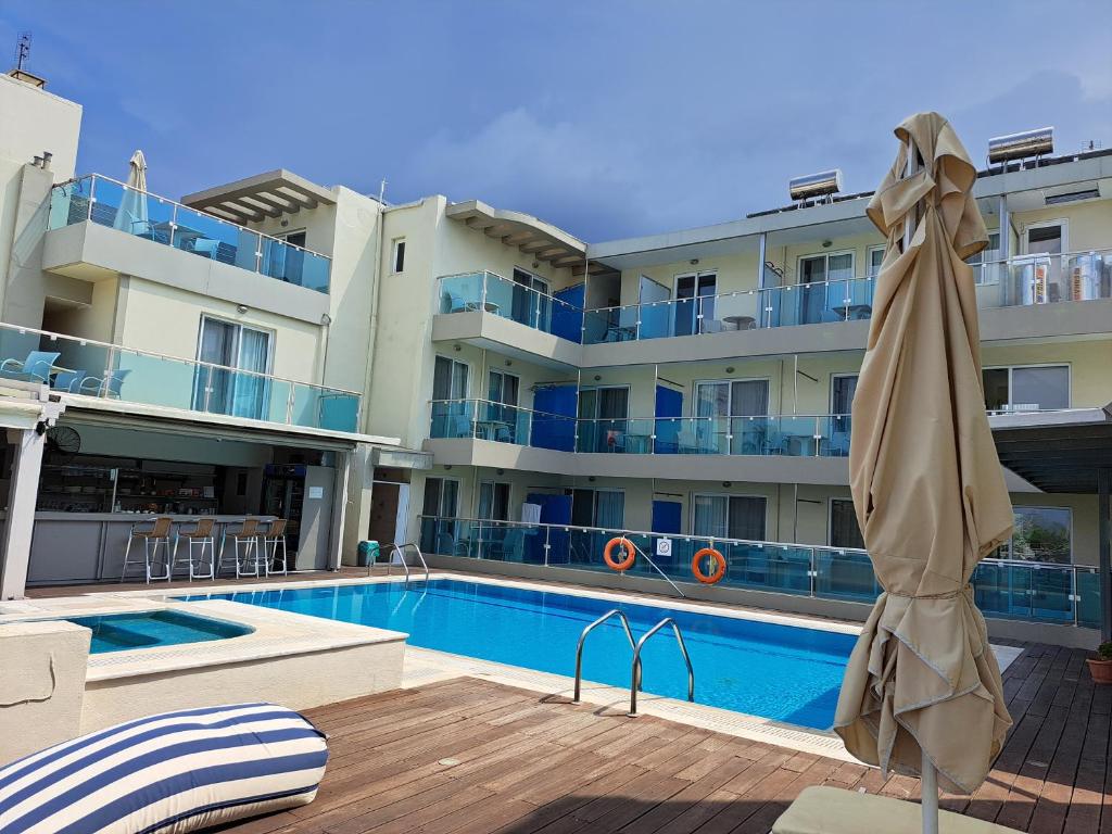 uma piscina com um guarda-sol ao lado de um edifício em Bristol Sea View Apartments em Cidade de Kos