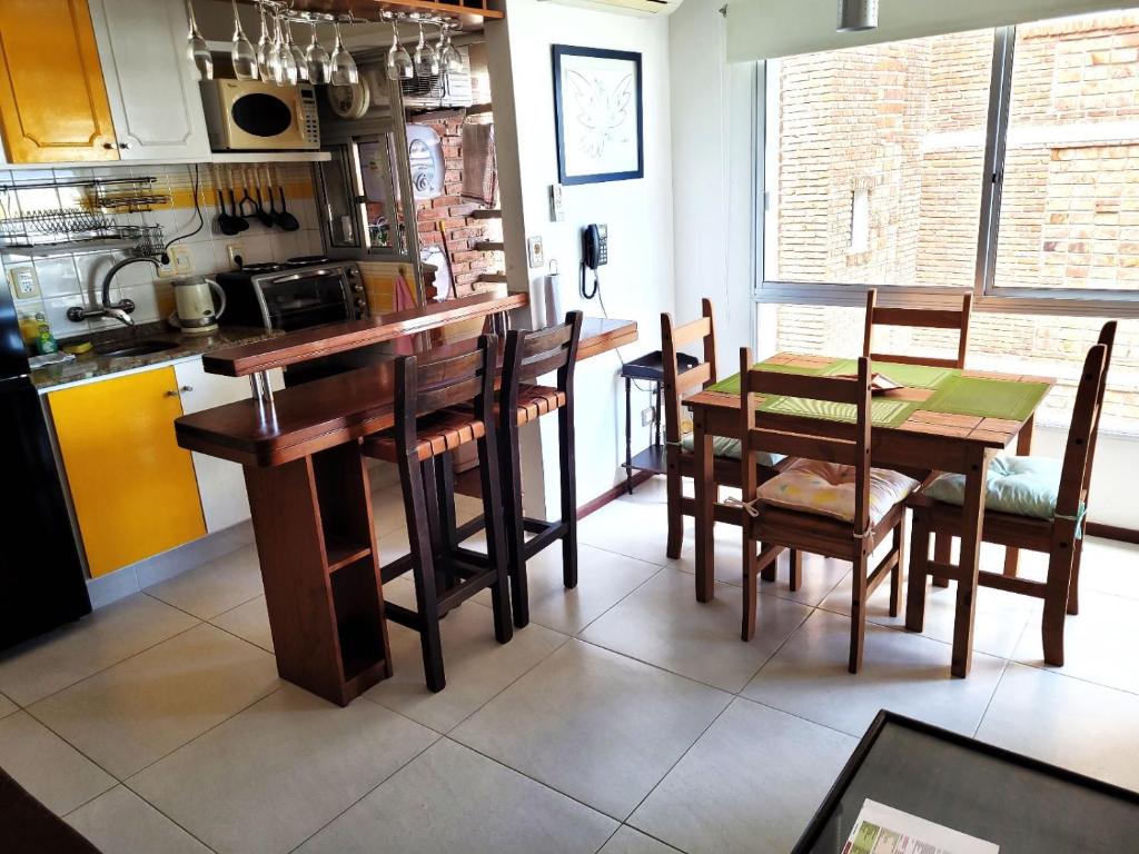 a kitchen with a table and some chairs and a table at APARTAMENTO 1 DORMITORIO EN PUNTA DEL ESTE in Punta del Este