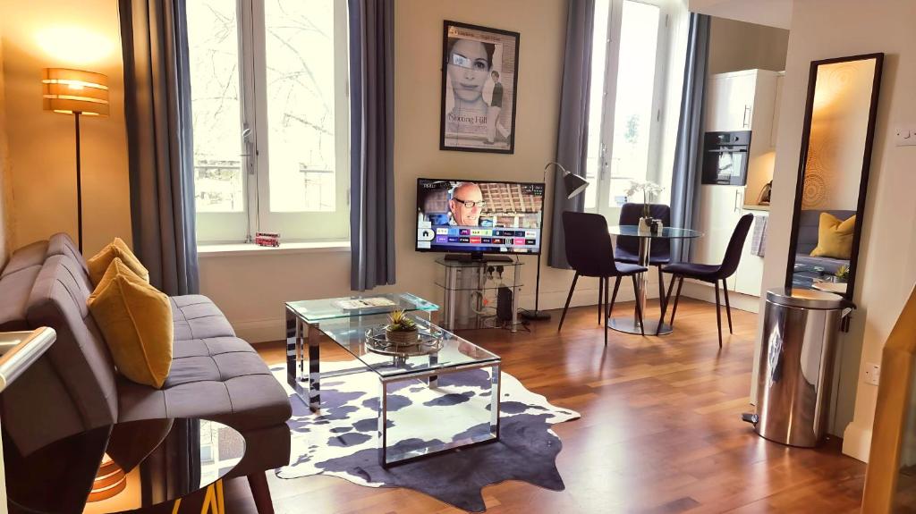 ein Wohnzimmer mit einem Sofa, einem Tisch und einem TV in der Unterkunft Notting Hill - The One One One!!! -3- in London