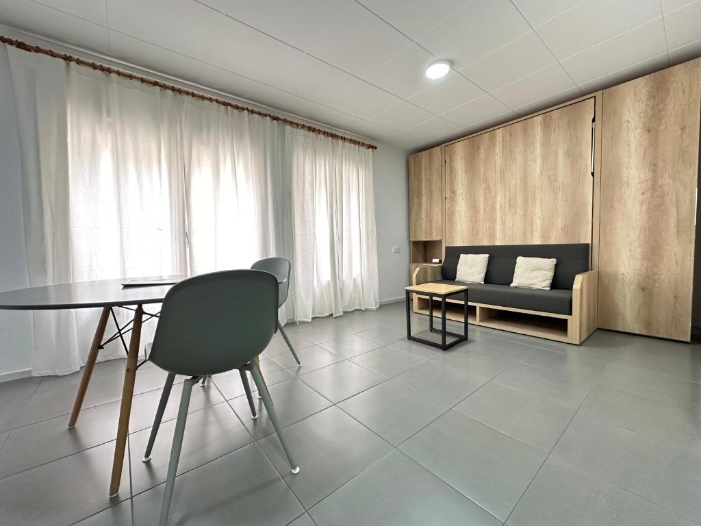 ein Wohnzimmer mit einem Tisch und einem Sofa in der Unterkunft Agi Arago Studio in Roses