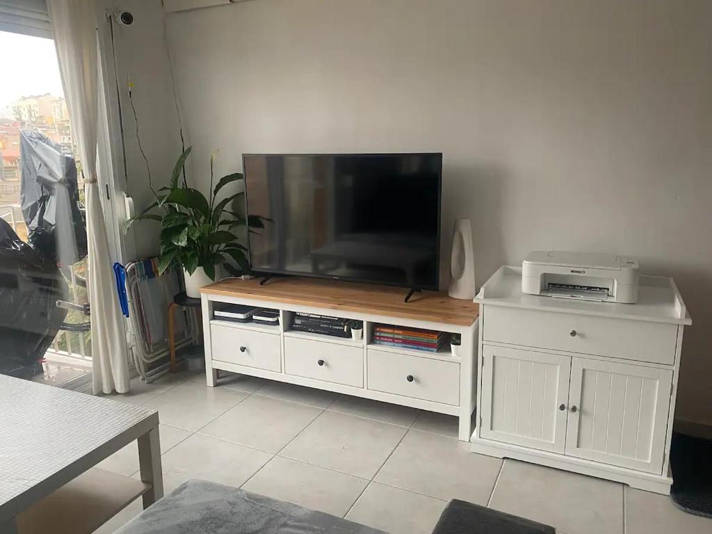 a flat screen tv sitting on top of a white cabinet at Barcelona Terrassa in Terrassa