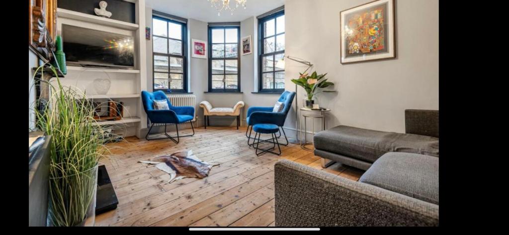 a living room with a couch and chairs and a tv at London Bridge with Van Parking upto 4 Vans cars Ideal for Builders ShopFitters secure cctv 3Bedrooms Balcony Boutique in London