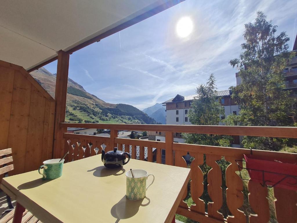 une table sur un balcon avec vue sur les montagnes dans l'établissement Super Venosc - E3 - Studio vue montagne 4pers, à Les Deux Alpes