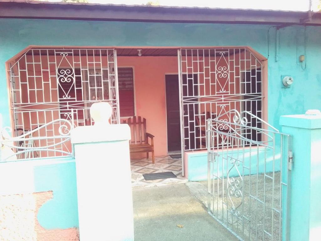 une maison bleue avec une porte en face dans l'établissement Port Antonio Residence, à Port Antonio