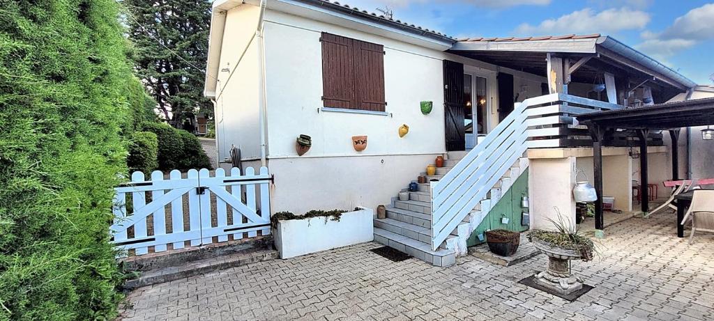 a house with a white fence and a white staircase at Maison paisible à Veyras avec piscine privée et vue montagne in Veyras