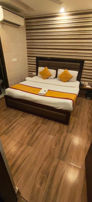 a bed with yellow pillows in a room at Hotel the Height kalkaji in New Delhi