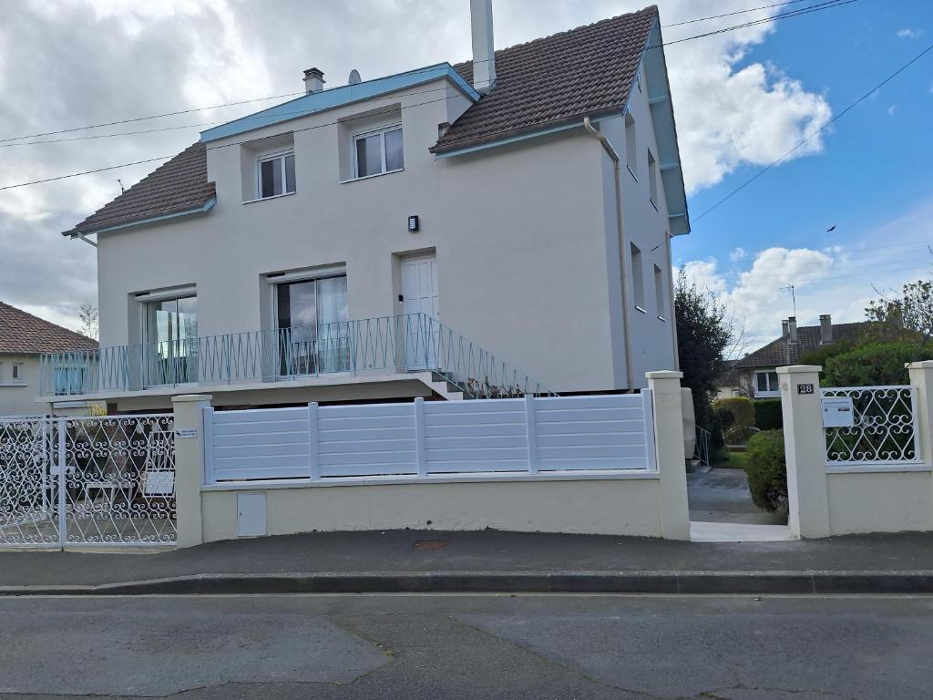 una casa blanca con una valla delante en La fleur du soleil, en Trouville-sur-Mer