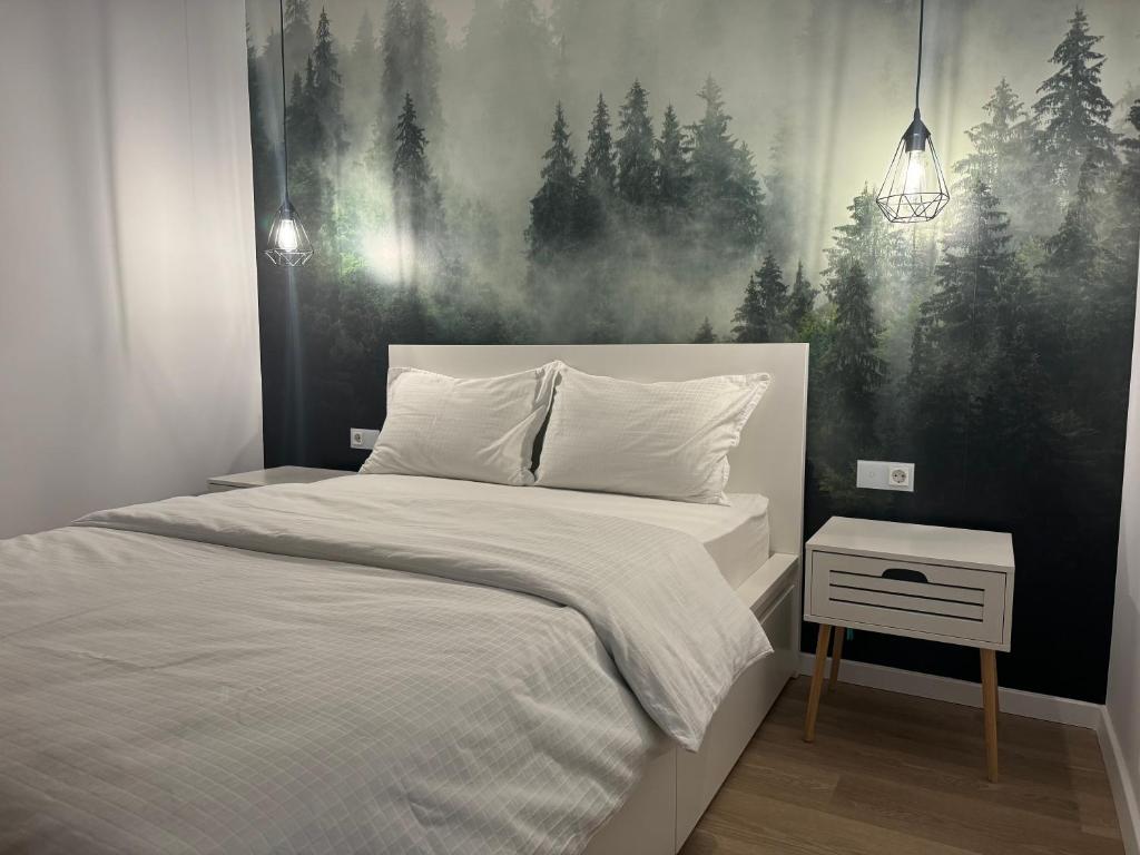 a bedroom with a bed and a painting on the wall at Modern și confortabil in Floreşti