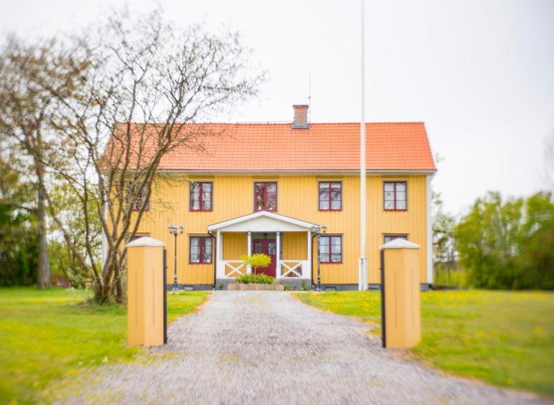 een geel huis met een pad ervoor bij Västervik rum & Stugor in Västervik