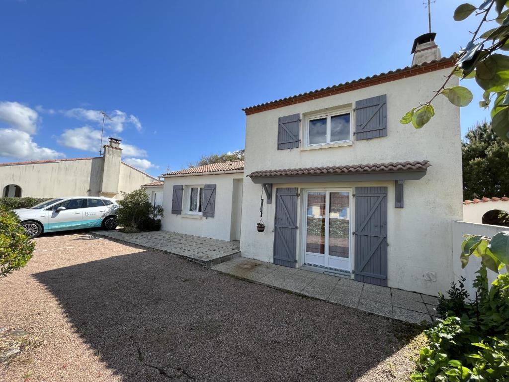 ein weißes Haus mit einem Auto in der Einfahrt in der Unterkunft La grande Seibel in Les Bussolleries