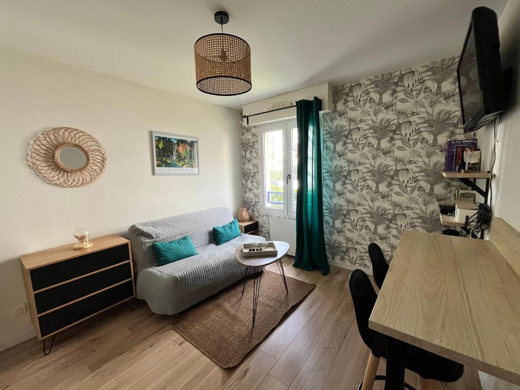 a living room with a couch and a table at Agréable Studio Calme - Proche Tramway et Centre in Nantes