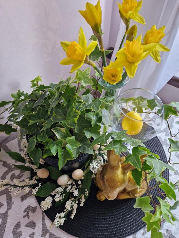 a table topped with yellow flowers in vases at CozyPlace in Kuldīga