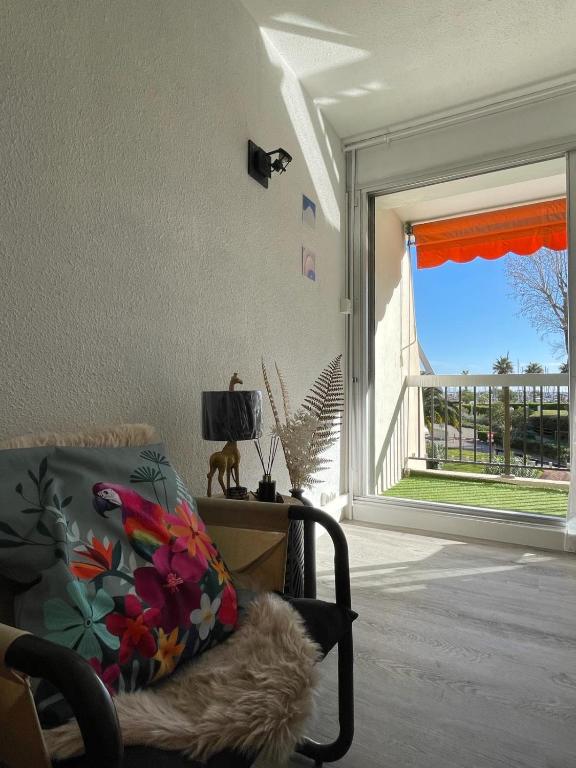 - un salon avec une grande fenêtre et une chaise dans l'établissement Le Nid d'Eden, à La Grande Motte