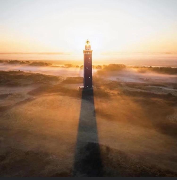 a lighthouse standing in the middle of a field at Vakantie appartement Goedereede let op de badkamer moet met andere gasten gedeeld worden in Goedereede