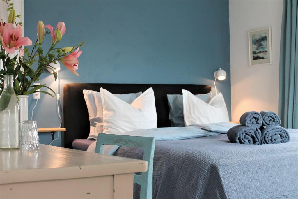 una camera da letto con un letto, un tavolo e fiori di Rosenhøj Bed and Breakfast a Svendborg