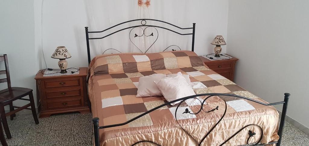 a bedroom with a bed and two night stands with lamps at Trullo Chiancola Antica in Alberobello