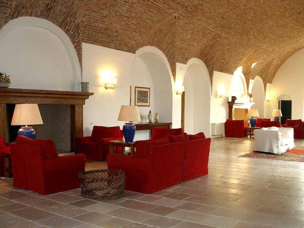 ein Wohnzimmer mit roten Stühlen und einem Kamin in der Unterkunft Relais Masseria Cardillo in Metaponto