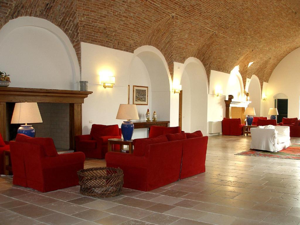 a living room with red chairs and a fireplace at Relais Masseria Cardillo in Metaponto