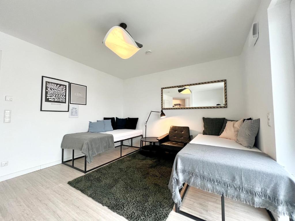 a white room with two beds and a mirror at Gemütliche Apartments direkt an der Grenze von Hamburg in Norderstedt