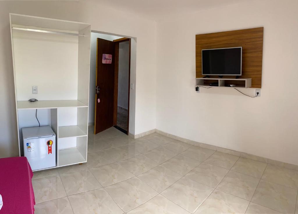 uma sala de estar com uma televisão na parede em Quatro Estações em Mata de São João