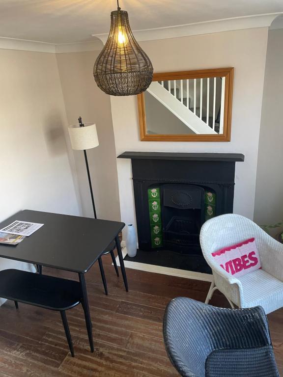 a living room with a table and chairs and a fireplace at Cozy Town House in Lewes