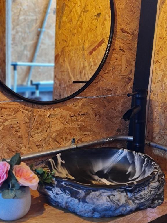 a bathroom sink with a mirror and a vase with flowers at Chalet Llano Grande in Rionegro