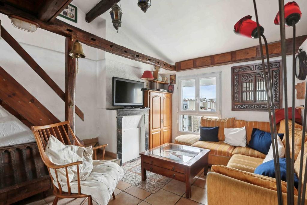 un salon avec un canapé et une cheminée dans l'établissement Le coeur de Paris, à Paris