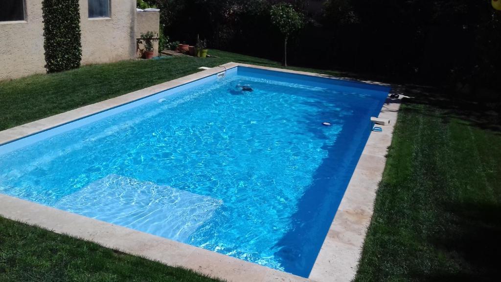 ein blauer Pool im Gras im Hof in der Unterkunft Jolie villa provençale avec piscine et vue mer in La Ciotat
