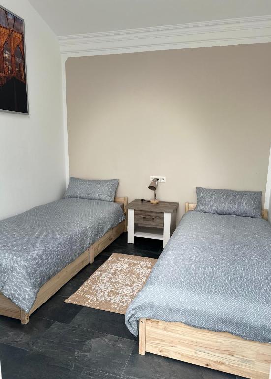 two twin beds in a room with a night stand at Ferienwohnung Steinebach in Steinebach